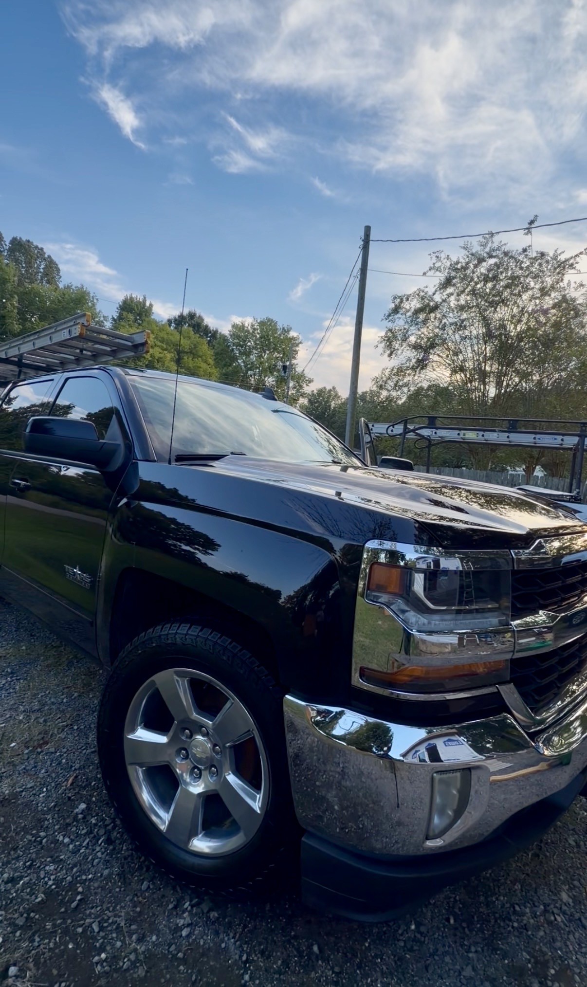 Finished black Chevrolet truck with reflections across the hood and fender