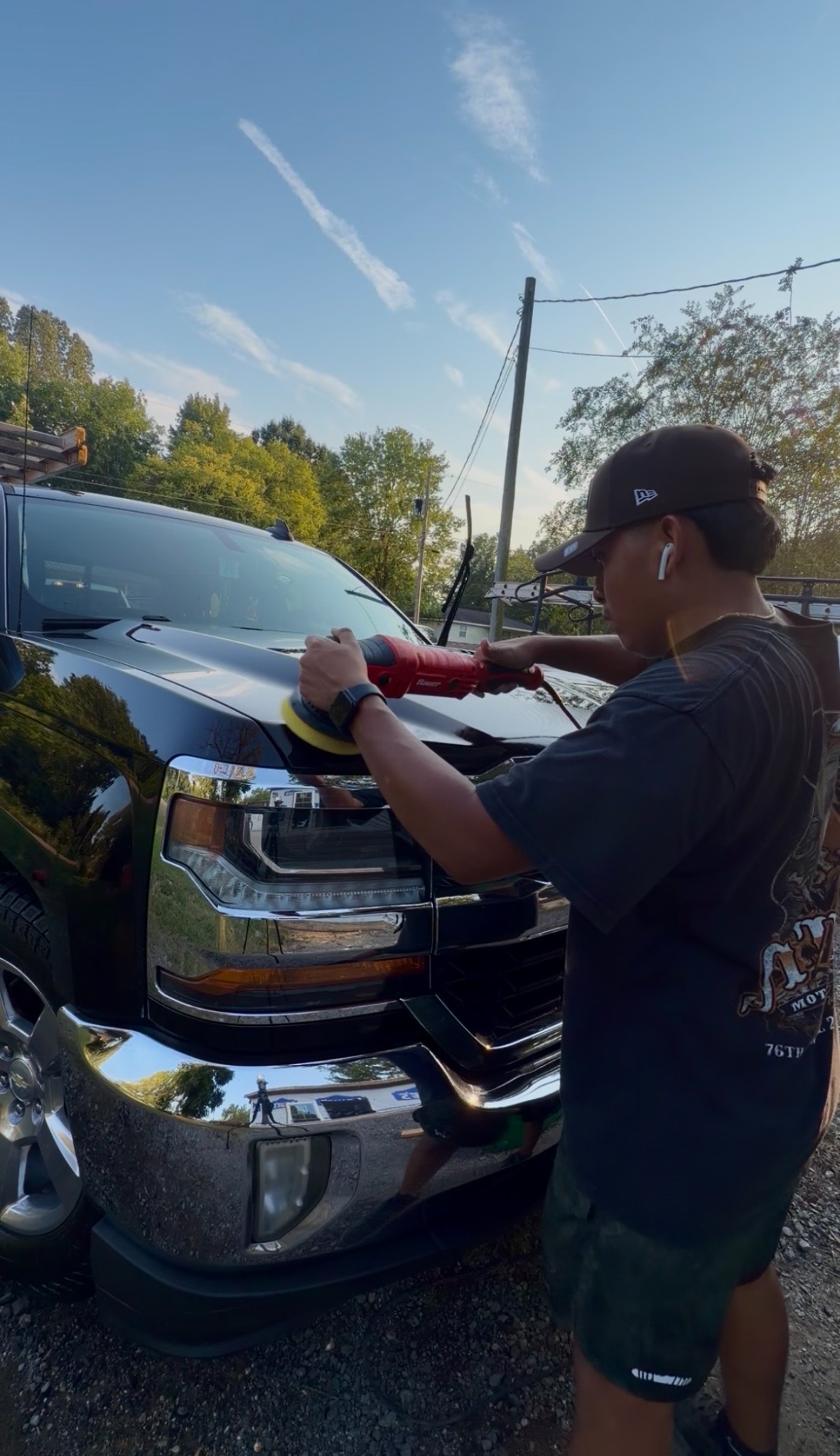 Machine polishing a black truck hood